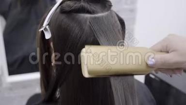 可爱的女孩，长着深色头发的<strong>理发</strong>师，在美容院做头发分层。 护发护理的概念